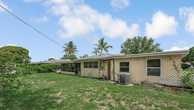 4840 Pineaire Ln, West Palm Beach, FL 33417 - rear view of property with a lawn and a sunroom