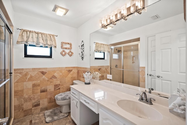 3003 SW Seaboard Ave, Palm City, FL 34990 - bathroom featuring tile walls, vanity, a stall shower, and wainscoting