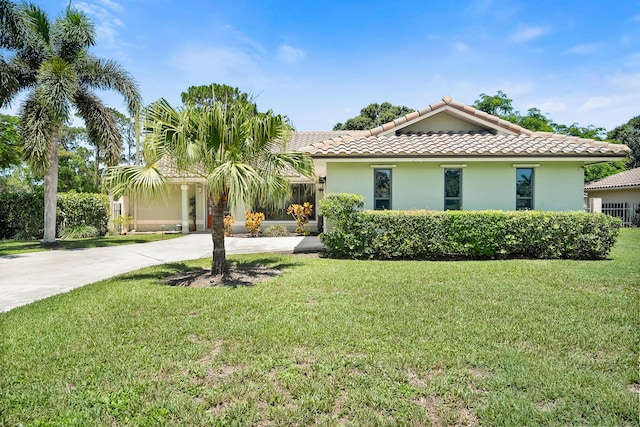 3003 SW Seaboard Ave, Palm City, FL 34990 - view of front of house featuring a tile roof, a front yard, stucco siding, and driveway