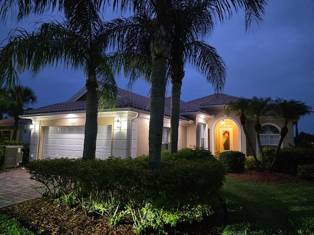 11355 SW Rockingham Dr, Port Saint Lucie, FL 34987 - view of front of home with an attached garage, stucco siding, decorative driveway, and a tiled roof