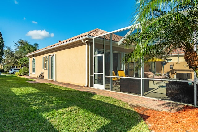 11355 SW Rockingham Dr, Port Saint Lucie, FL 34987 - rear view of house featuring a tile roof, stucco siding, and a lawn