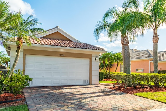 11355 SW Rockingham Dr, Port Saint Lucie, FL 34987 - mediterranean / spanish home with decorative driveway, stucco siding, and a tiled roof