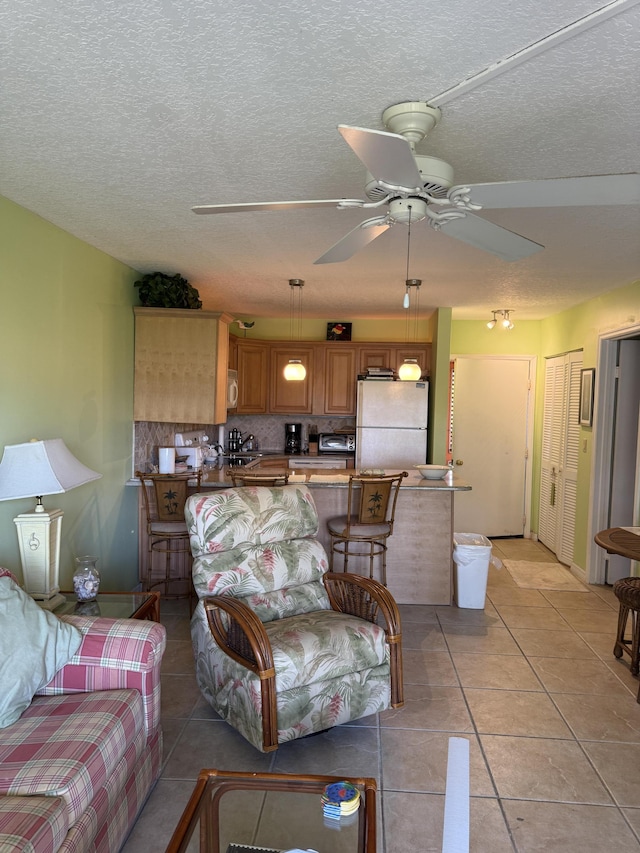 2400 S Ocean Dr S Unit 1011, Fort Pierce, FL 34949 - living area featuring a ceiling fan, light tile patterned flooring, and a textured ceiling