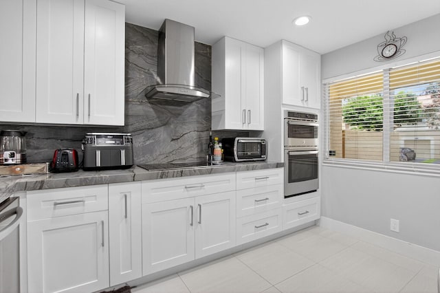 3469 Deer Creek Palladian Cir, Deerfield Beach, FL 33442 - kitchen with black electric cooktop, wall chimney exhaust hood, backsplash, double oven, and white cabinets