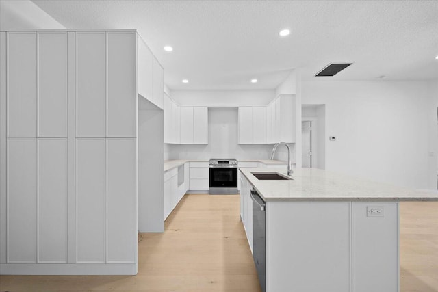 204 Clocktower Dr, Jupiter, FL 33458 - kitchen featuring stainless steel appliances, light stone countertops, light wood-type flooring, white cabinetry, and recessed lighting