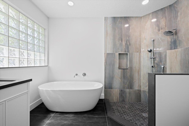 204 Clocktower Dr, Jupiter, FL 33458 - full bath with a freestanding tub, a walk in shower, vanity, tile patterned flooring, and recessed lighting