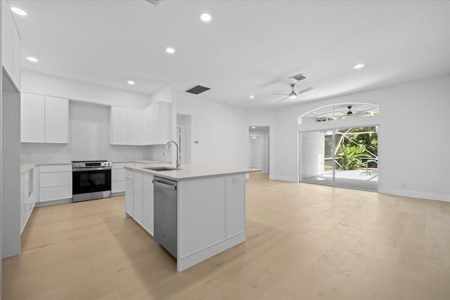 204 Clocktower Dr, Jupiter, FL 33458 - kitchen featuring stainless steel appliances, ceiling fan, light countertops, white cabinetry, and light wood finished floors