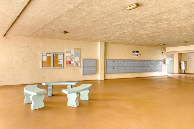 300 Village Green Cir S Unit 120, Palm Springs, FL 33461 - misc room with mail area, a textured wall, and concrete floors