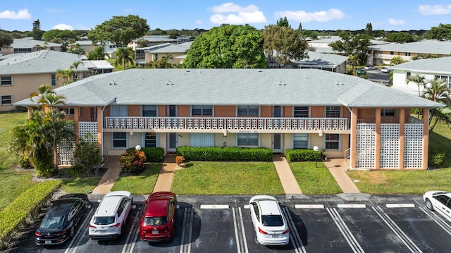 1630 NW 18th Ave Unit 101, Delray Beach, FL 33445 - view of front facade with uncovered parking, a front yard, a residential view, and a shingled roof