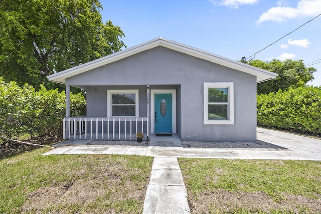 126 NW 6th Ave, Delray Beach, FL 33444 - bungalow-style home featuring a porch, stucco siding, and a front yard