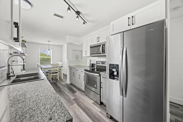 126 NW 6th Ave, Delray Beach, FL 33444 - kitchen featuring appliances with stainless steel finishes, dark wood-type flooring, white cabinets, and track lighting