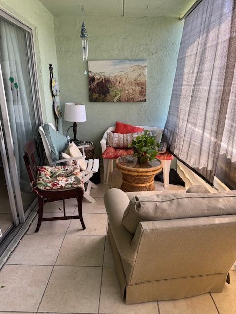 3000 Springdale Blvd Unit V204, Palm Springs, FL 33461 - living area featuring light tile patterned floors and a textured wall