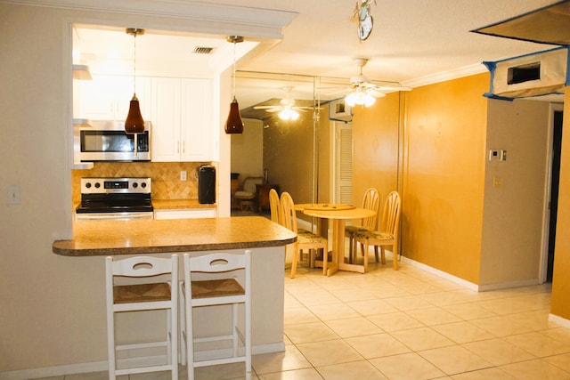 455 High Point Blvd Unit D, Delray Beach, FL 33445 - kitchen featuring appliances with stainless steel finishes, ceiling fan, backsplash, white cabinetry, and crown molding