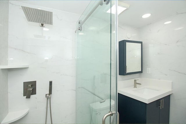 3580 Dunes Rd, Palm Beach Gardens, FL 33410 - bathroom featuring vanity, a marble finish shower, and tile walls