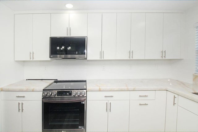 3580 Dunes Rd, Palm Beach Gardens, FL 33410 - kitchen featuring stainless steel appliances, white cabinetry, light stone countertops, and backsplash
