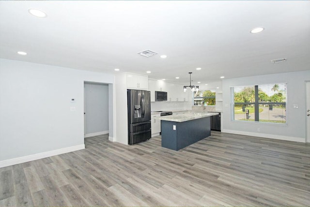 3580 Dunes Rd, Palm Beach Gardens, FL 33410 - kitchen featuring black appliances, a center island, recessed lighting, open floor plan, and white cabinets