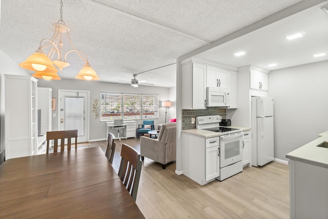 2054 Cornwall C, Boca Raton, FL 33434 - kitchen with white appliances, light countertops, light wood-type flooring, white cabinets, and a textured ceiling