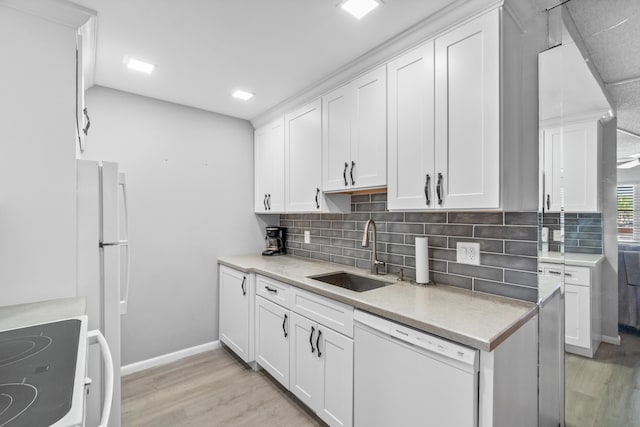 2054 Cornwall C, Boca Raton, FL 33434 - kitchen with white appliances, light wood finished floors, light countertops, white cabinets, and backsplash