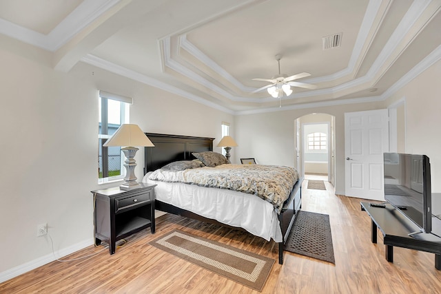 3601 SW Europe St, Port Saint Lucie, FL 34953 - bedroom with arched walkways, light wood-type flooring, a raised ceiling, ornamental molding, and a ceiling fan