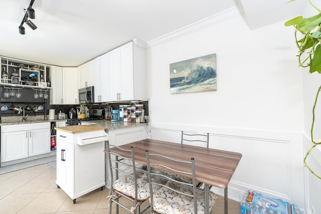 2140 White Pine Cir Unit A, Greenacres, FL 33415 - kitchen with appliances with stainless steel finishes, tasteful backsplash, white cabinetry, light tile patterned floors, and ornamental molding