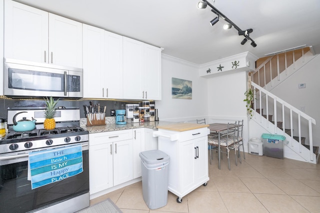 2140 White Pine Cir Unit A, Greenacres, FL 33415 - kitchen featuring stainless steel appliances, light tile patterned floors, white cabinets, ornamental molding, and light stone countertops