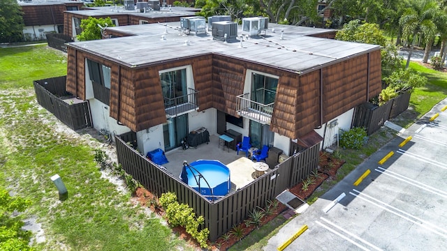 2140 White Pine Cir Unit A, Greenacres, FL 33415 - back of house with a fenced backyard, an outdoor pool, a patio area, and a balcony