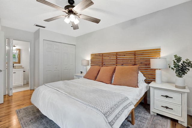 5914 SE Mitzi Ln, Stuart, FL 34997 - bedroom featuring light wood-style flooring, a closet, a ceiling fan, and connected bathroom