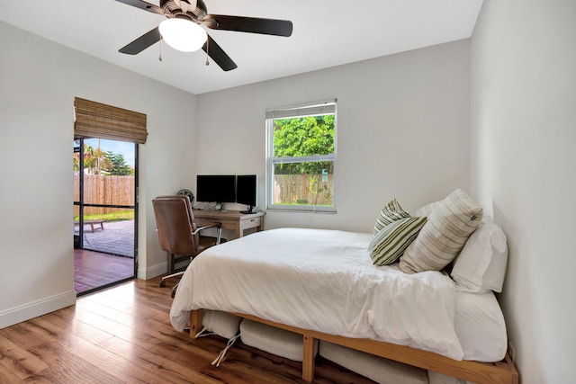 5914 SE Mitzi Ln, Stuart, FL 34997 - bedroom featuring access to exterior, multiple windows, wood finished floors, and a ceiling fan