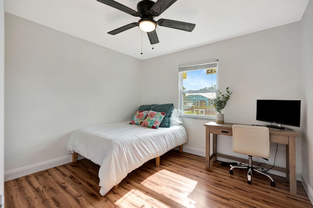 5914 SE Mitzi Ln, Stuart, FL 34997 - bedroom with wood finished floors, a desk, and a ceiling fan