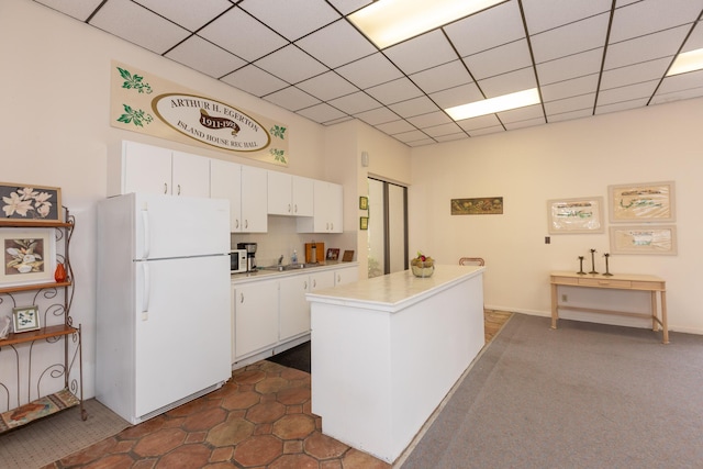 2050 Oleander Blvd Unit 5301, Fort Pierce, FL 34950 - kitchen featuring freestanding refrigerator, white cabinets, light countertops, and a drop ceiling