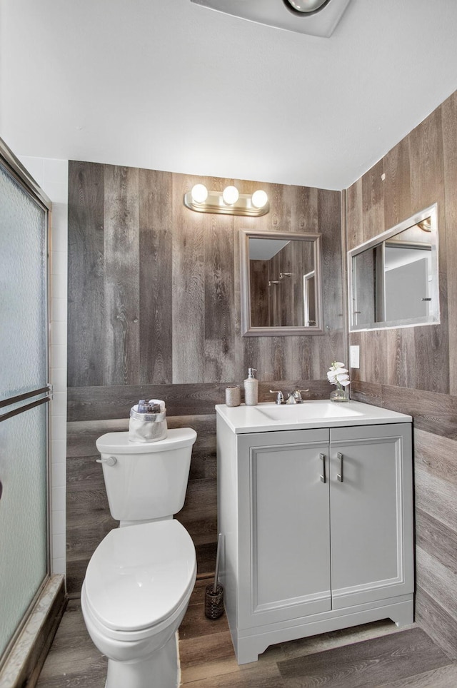 363 Sheffield O, West Palm Beach, FL 33417 - bathroom featuring vanity, wood walls, wood finished floors, and a shower with door