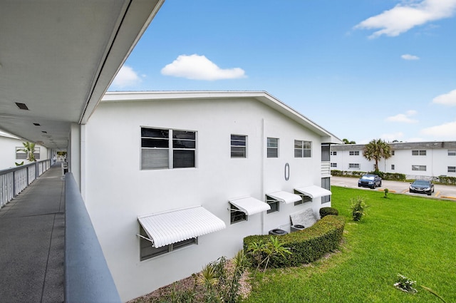 363 Sheffield O, West Palm Beach, FL 33417 - view of property exterior with a yard and stucco siding