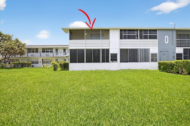 363 Sheffield O, West Palm Beach, FL 33417 - back of house featuring a lawn and stucco siding