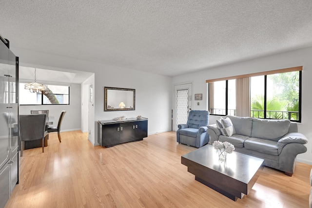 15126 Ashland St Unit 250, Delray Beach, FL 33484 - living room featuring a textured ceiling, light wood finished floors, and a chandelier