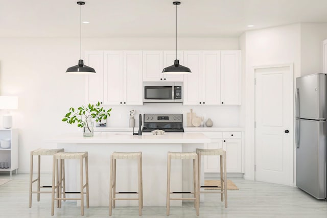 650 NE Waters Edge Ln, Port Saint Lucie, FL 34983 - kitchen featuring appliances with stainless steel finishes, white cabinetry, hanging light fixtures, a kitchen island with sink, and light countertops
