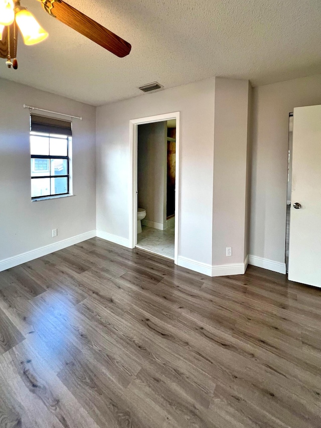 9815 Watermill Cir Unit B, Boynton Beach, FL 33437 - unfurnished bedroom with wood finished floors, a textured ceiling, ensuite bathroom, and a ceiling fan