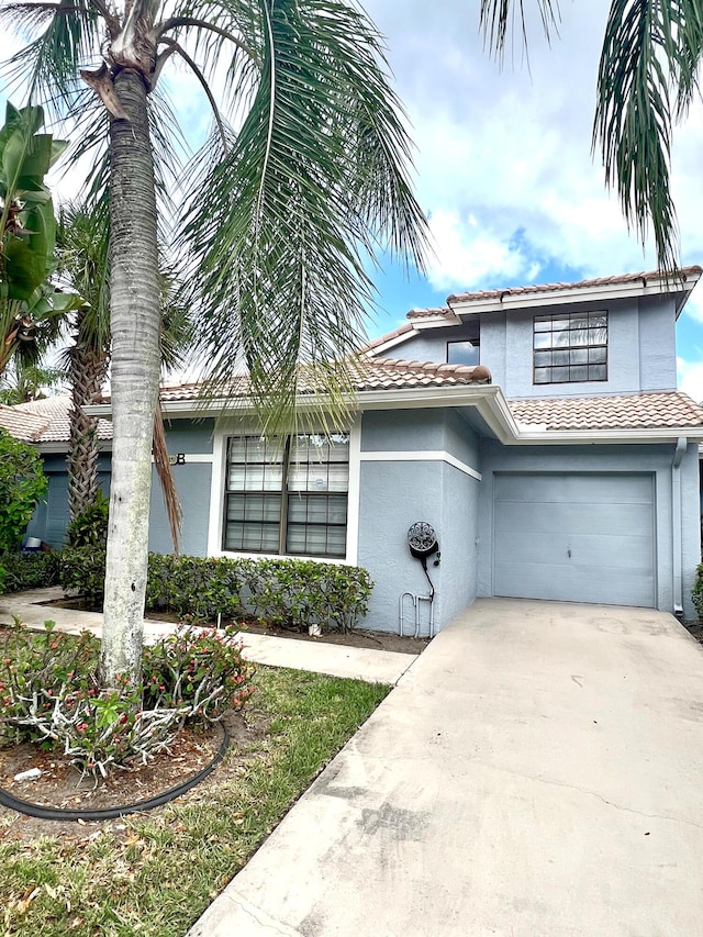 9815 Watermill Cir Unit B, Boynton Beach, FL 33437 - view of front of house featuring stucco siding, concrete driveway, and a garage