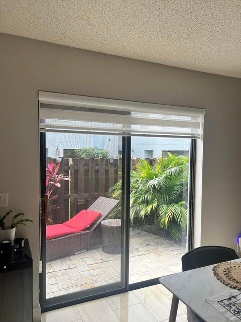 9815 Watermill Cir Unit B, Boynton Beach, FL 33437 - doorway to outside featuring a textured ceiling