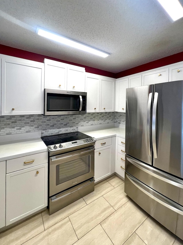 9815 Watermill Cir Unit B, Boynton Beach, FL 33437 - kitchen with stainless steel appliances, light countertops, white cabinetry, tasteful backsplash, and a textured ceiling