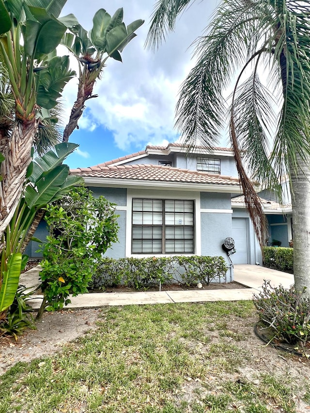 9815 Watermill Cir Unit B, Boynton Beach, FL 33437 - view of front facade featuring stucco siding, a garage, a tile roof, and driveway