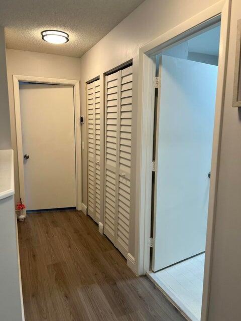 9815 Watermill Cir Unit B, Boynton Beach, FL 33437 - hallway featuring wood finished floors and a textured ceiling