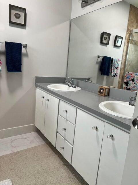 9815 Watermill Cir Unit B, Boynton Beach, FL 33437 - bathroom featuring double vanity, a shower stall, and marble finish floors