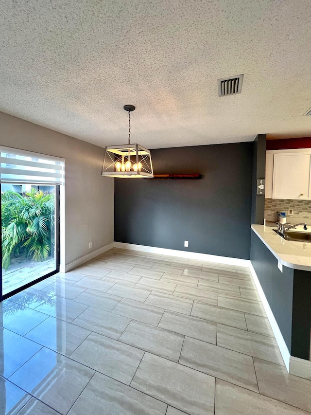 9815 Watermill Cir Unit B, Boynton Beach, FL 33437 - unfurnished dining area featuring a chandelier and a textured ceiling