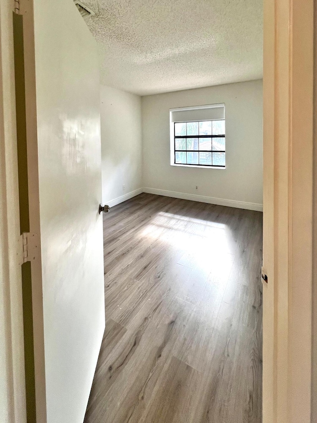 9815 Watermill Cir Unit B, Boynton Beach, FL 33437 - empty room featuring wood finished floors and a textured ceiling