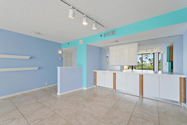 300 Ocean Trail Way Unit 102, Jupiter, FL 33477 - unfurnished room featuring a textured ceiling, light tile patterned flooring, and track lighting