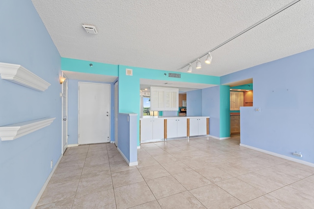 300 Ocean Trail Way Unit 102, Jupiter, FL 33477 - unfurnished room featuring a textured ceiling, light tile patterned flooring, and track lighting