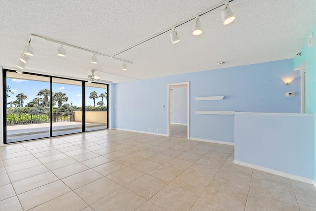 300 Ocean Trail Way Unit 102, Jupiter, FL 33477 - unfurnished room with rail lighting, a textured ceiling, light tile patterned floors, and expansive windows