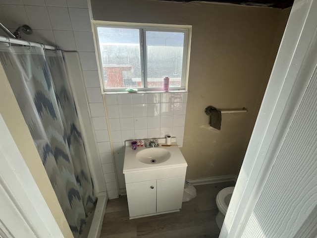 628 W 7th St, Riviera Beach, FL 33404 - full bathroom with curtained shower, wood finished floors, tile walls, and vanity