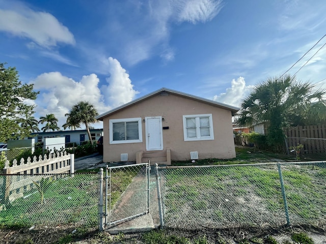628 W 7th St, Riviera Beach, FL 33404 - bungalow-style house featuring stucco siding and a gate