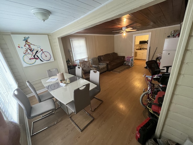 628 W 7th St, Riviera Beach, FL 33404 - dining area with wood ceiling, light wood finished floors, ceiling fan, wooden walls, and crown molding
